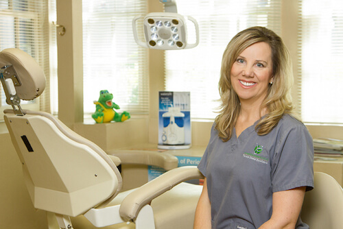 Dr. Jacqueline Bennett sitting near a dental exam chair